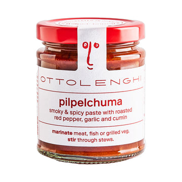 Jar of Ottolenghi pilpelchuma paste with red lid on a white background.