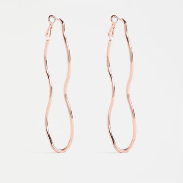 Rose gold wavy earrings on a light gray background.