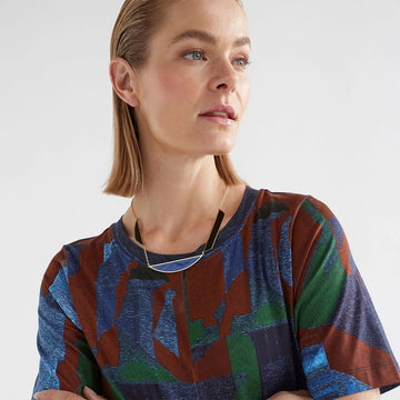 A gold chain necklace with two black and one blue shape linked into the chain.