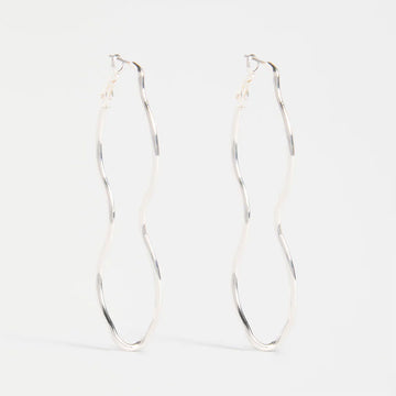 Pair of silver hoop wavy earrings on a white background.