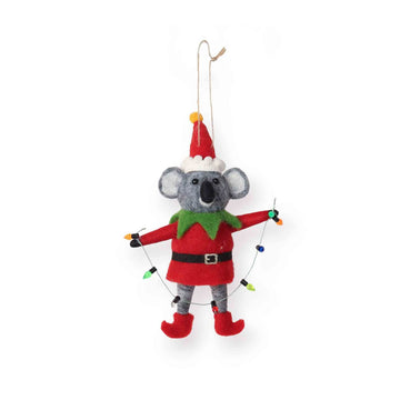 Christmas-themed koala ornament in elf costume holding a string of Christmas lights on a white background.