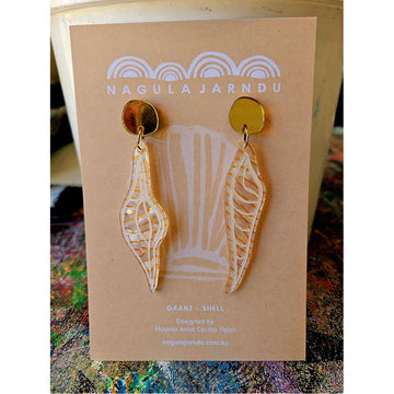 A pair of orange long shell shaped earrings attached to a light orange product card.
