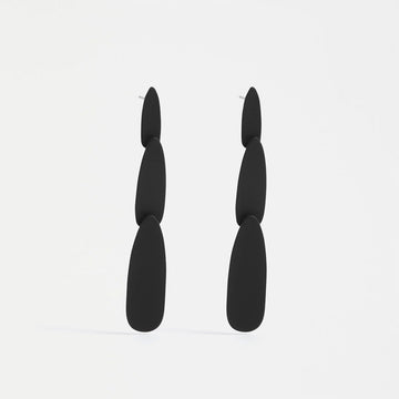 A pair of stud drop earrings featuring three different sized black ovals.