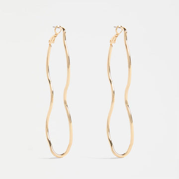Gold wavy hoop earrings on a light gray background.