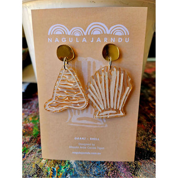 A pair of orange long shell shaped earrings attached to a light orange product card.