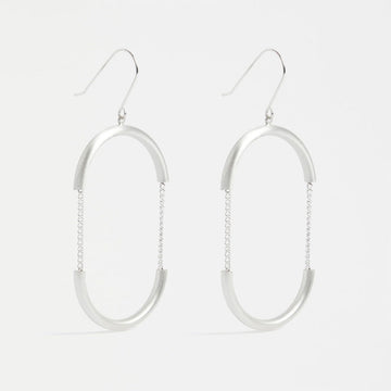 A pair of drop earrings in silver with the outline of an oval with chain details in the middle.
