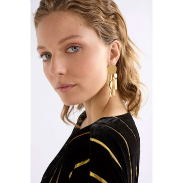 Gold geometric earrings on a light gray background.