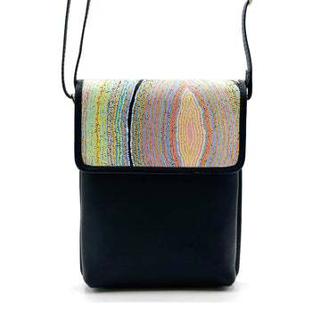A black leather sling bag printed with artwork by Liddy Walker on the flap.