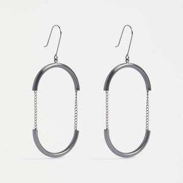 A pair of drop earrings in gunmetal grey with the outline of an oval with chain details in the middle.