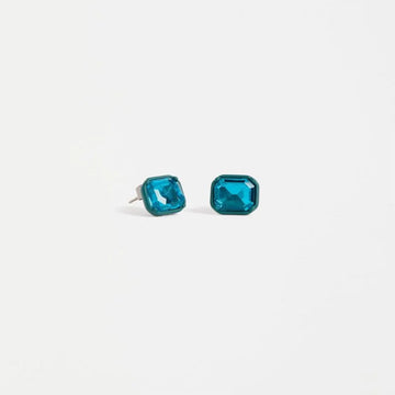 A pair of stud earrings shaped like a blue jewel.