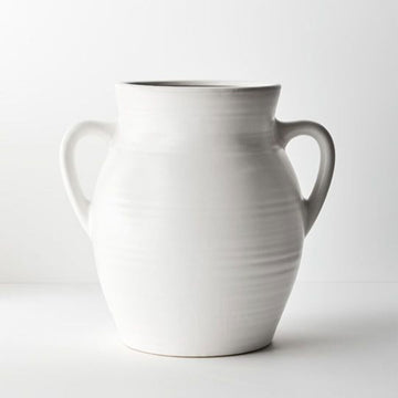 A large white ceramic vase in a tall round shape with handles on either side.