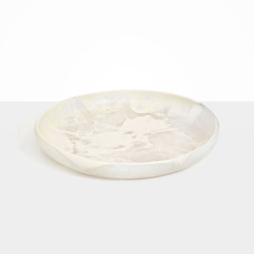 A large round shallow bowl made from cream coloured resin.