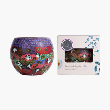 Decorative candle holder with colorful patterns next to its packaging box on a white background.