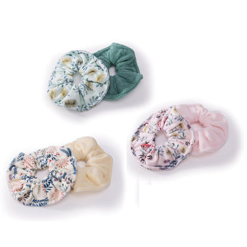 Three sets of scrunchies in groups of two. Each set has one plain coloured and one floral printed scrunchie.