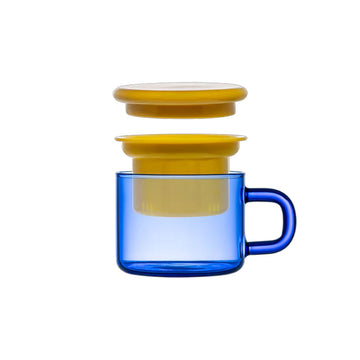 A glass mug in blue with a yellow lid and infuser inside.