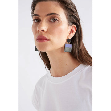 A pair of stud drop earrings with a grey square at the top and a larger square at the bottom with half purple and half grey inside it.