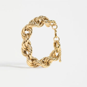 A gold bracelet made up of lots of chains on a white background.