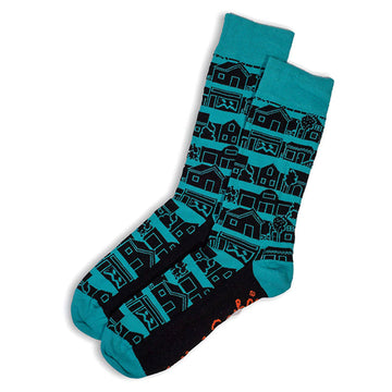 A pair of teal blue socks printed with black silhouettes of houses.