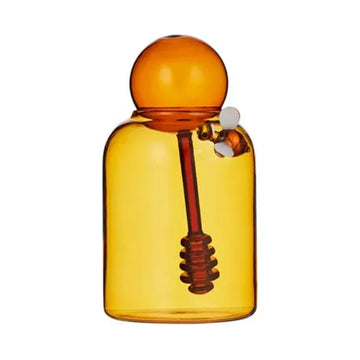 Amber glass bottle with bee and stirrer inside.