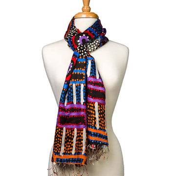 A silk scarf printed with artwork by Watson Robertson is tied around the neck of a mannequin.