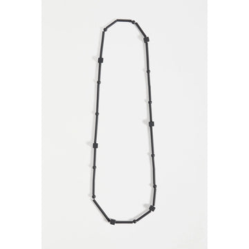 A necklace made up of long cylinder beads with circular and square beads in between all in black.