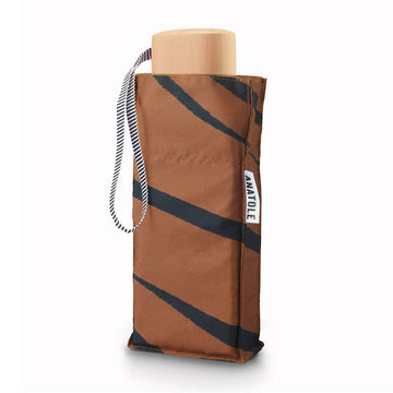 A folded up umbrella in a square pouch printed with tiger stripes.
