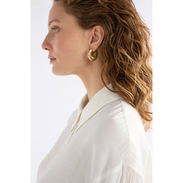 Gold hoop earrings on a light gray background.