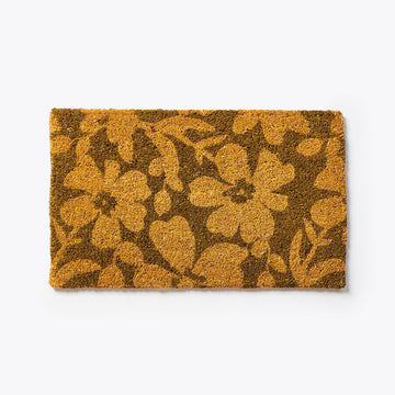 A brown door mat printed with golden brown flowers.
