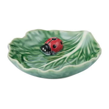 Ceramic leaf-shaped dish with a ladybug on a white background.
