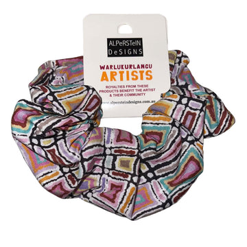A cotton scrunchie printed with artwork by Lynette Nangala Singleton in a colourful rectangle pattern.