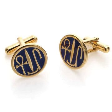 A pair of round gold cufflinks with Egyptian symbols on them. 