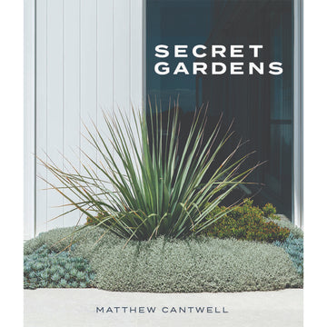 'Secret Garden's book cover featuring a photo of a plant surrounded by shrubs in front of a window.