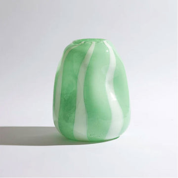 A glass vase with convex shapes and a green and white striped pattern.