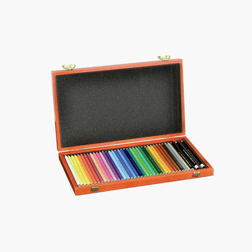 Set of colored pencils and a black pencil in an open wooden case on a white background.