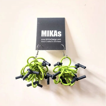 A pair of hook earrings featuring green rubber in a twisted shape with black ends attached.