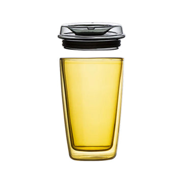 Yellow glass container filled with liquid on a beige background.