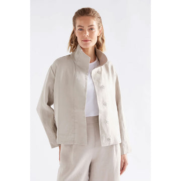 Woman wearing a beige jacket and pants on a white background.