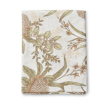 A folded up table cloth illustrated with flowers and leaves.