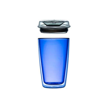 Blue glass tumbler with a black rim on a beige background.
