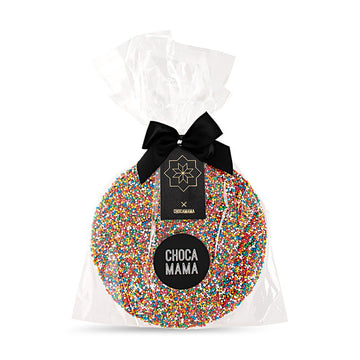 A large round chocolate covered with sprinkles in clear packaging and a brand label with the name 'Chocamama'.