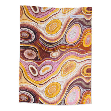 A linen teatowel printed with Indigenous artwork in shades of pink and brown.