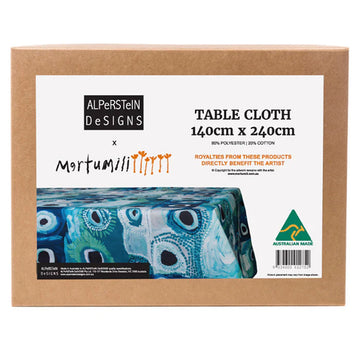 A brown box with a large label on the front with the heading 'Table Cloth' and a photo of the table cloth inside with artwork by May Wokka Chapman.