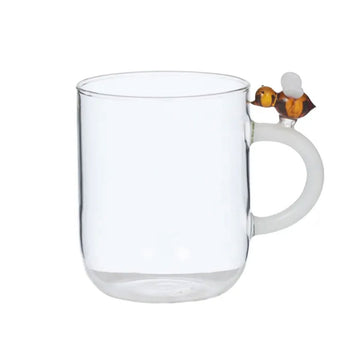 Clear glass mug with a bee design on the handle on a white background.