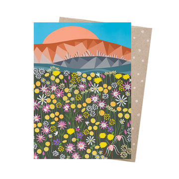 Greeting card with a colorful floral design and mountain landscape on a white background.