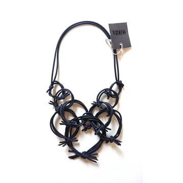 A necklace made up of black rubber strands in circle shapes with tied together ends that look spiky.