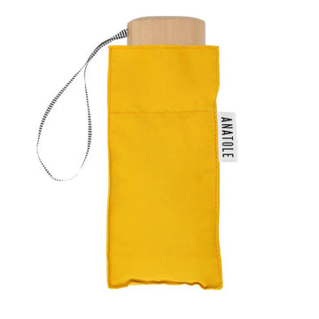 A folded up umbrella in yellow in a square shaped pouch.