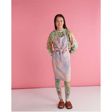 A linen apron printed with an orange and purple Indigeneous print.