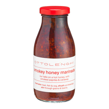 Bottle of Ottolenghi smoky honey marinade with a red cap on a white background.