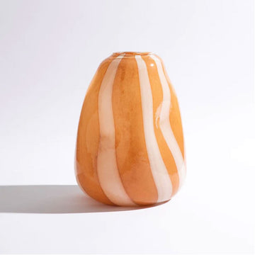 A glass vase with convex shapes and an orange and white striped pattern.