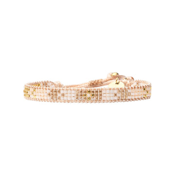 A beaded bracelet with four rows in gold and beige.